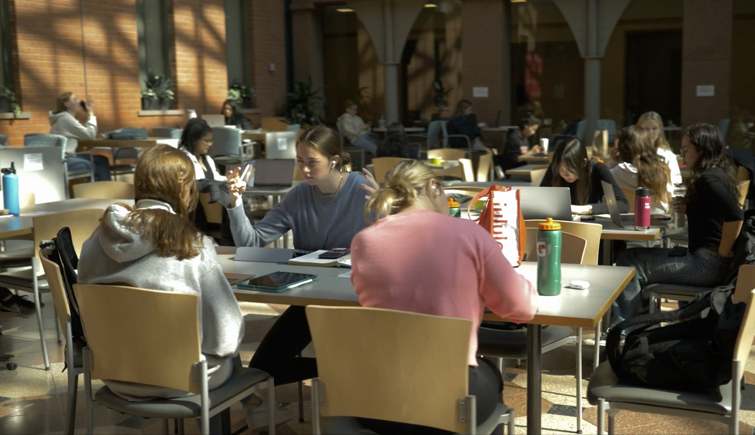 Students sitting at tables and doing school work