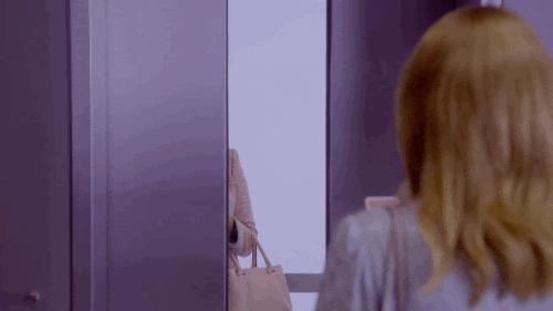 Lacie from the Black Mirror episode “Nosedive” turning around with a phone in her hand smiling and then frowning